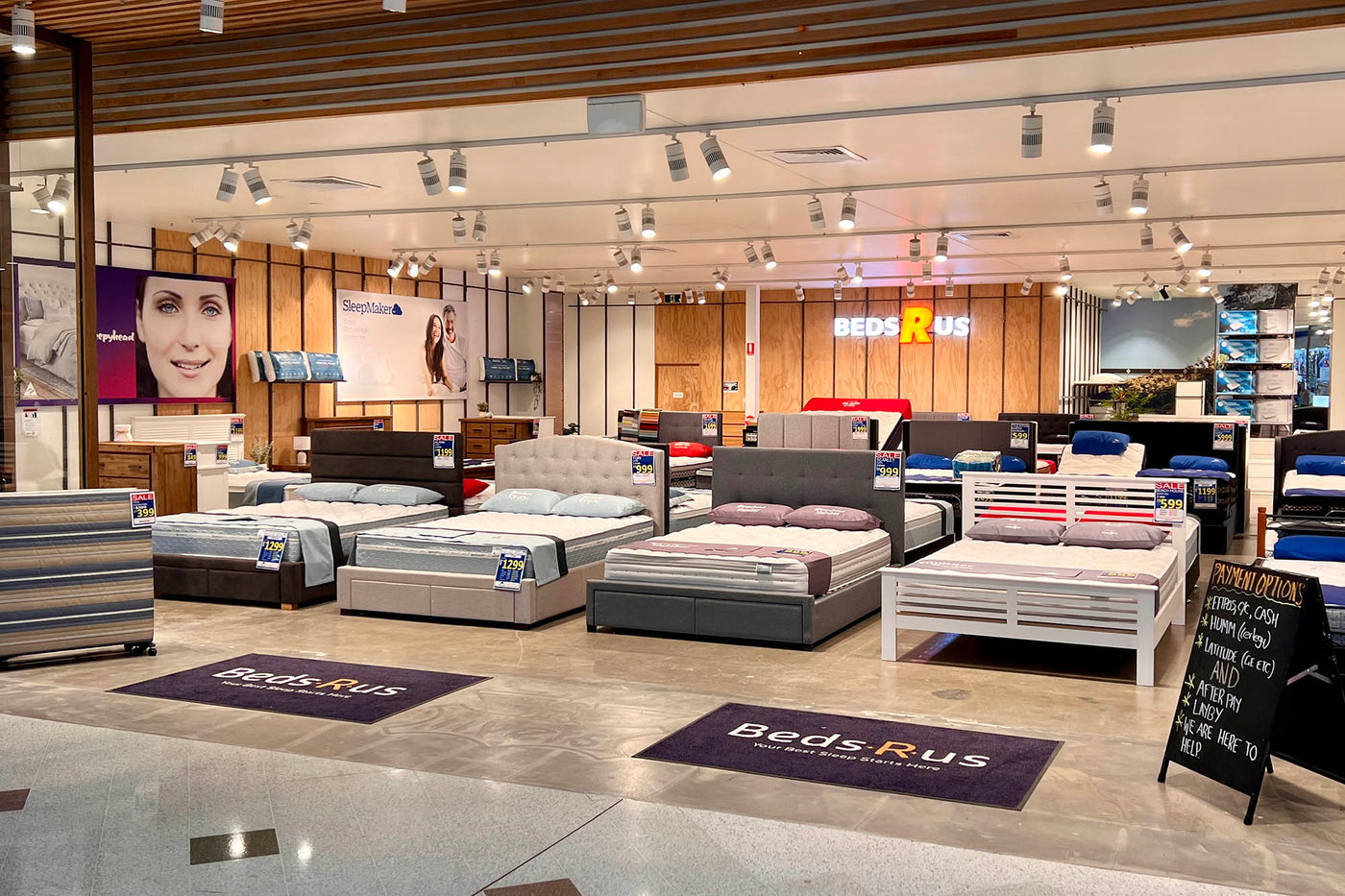 Beds R Us Loganholme store interior with various mattresses on display.